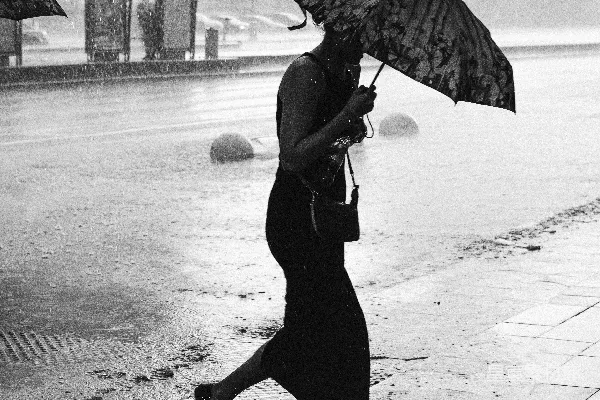 一个女人打着伞在雨中走着。