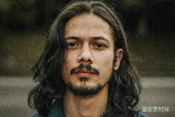 一个留长发的男人穿着绿色的衬衫