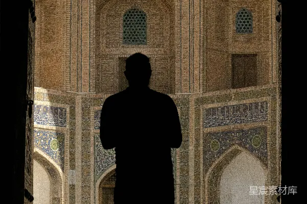 一个男子的轮廓映衬在繁复的清真寺建筑风格中。