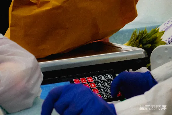 戴着手套的手在秤上称重农产品