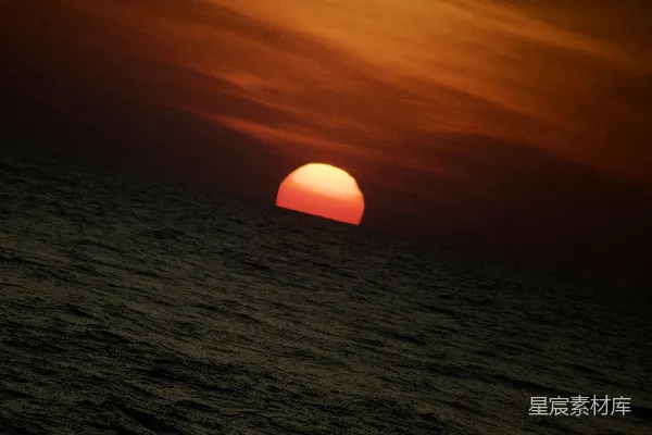 阴天的某一天，太阳正在海边落下。