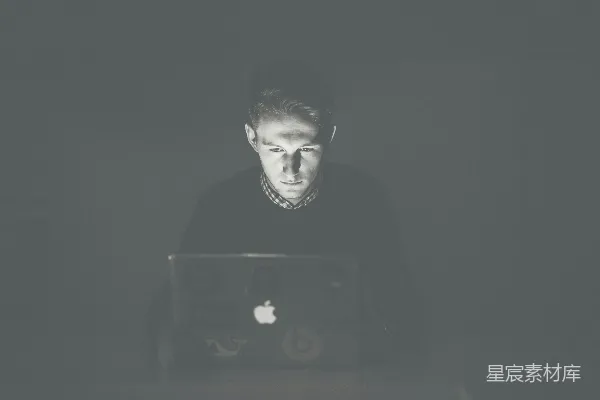 男人盯着黑色的MacBook