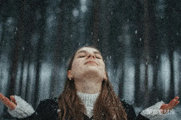 一个女人伸开双臂站在雪中