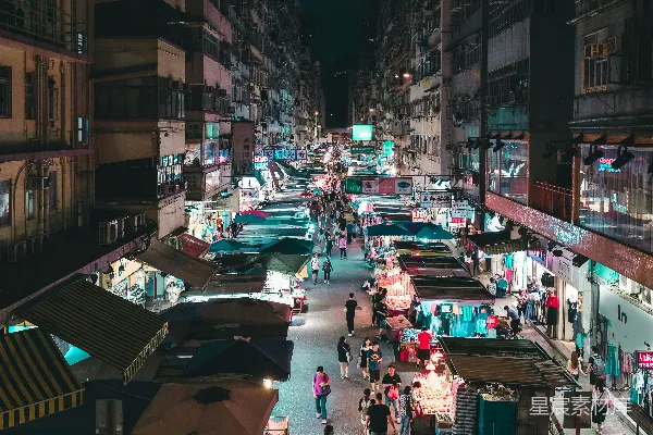 夜间人们走在近处建筑物之间的道路上