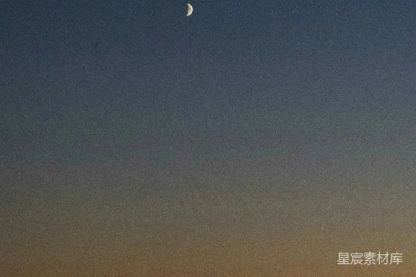 天边暗淡夜景中一轮残月映衬轮廓景观