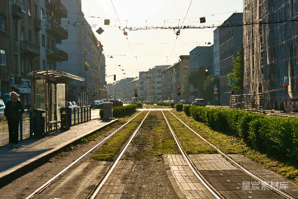 有轨电车轨道穿过一条城市街道，旁边是建筑物。