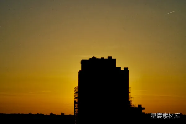 夕阳落在一栋高大建筑物的背后。