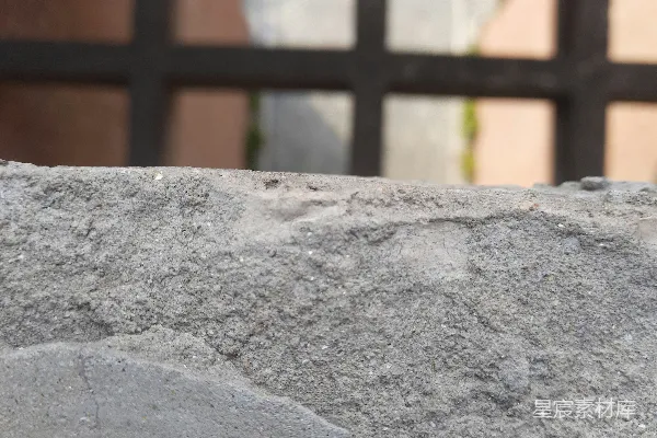 高清摄影 一张岩石的特写照片，背景中可以看到一座建筑物。