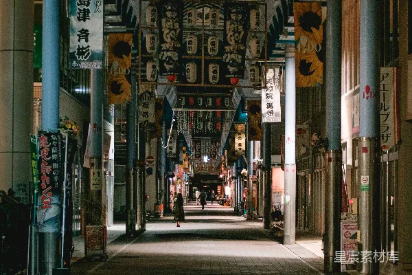 夜幕下行人走在人行道上