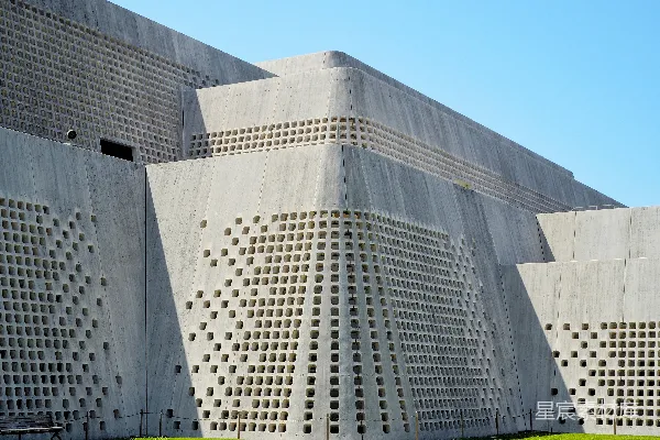 高清摄影 一幢由混凝土块建造的建筑，侧面有孔洞。