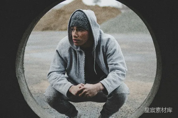 白天一名男子坐在灰色隧道附近