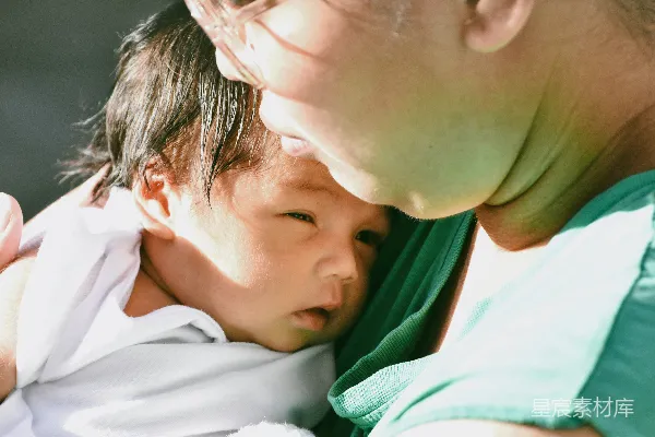 一位母亲温柔地抱着她刚出生的婴儿。
