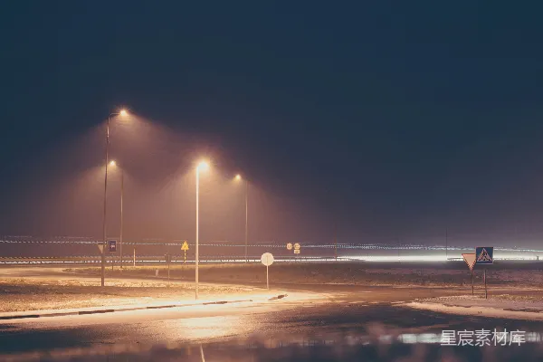 夜间有路灯的道路铺着混凝土路面。