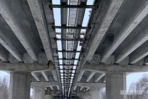 高清摄影 混凝土桥梁和管道横跨在雪后的冬季景观之上。