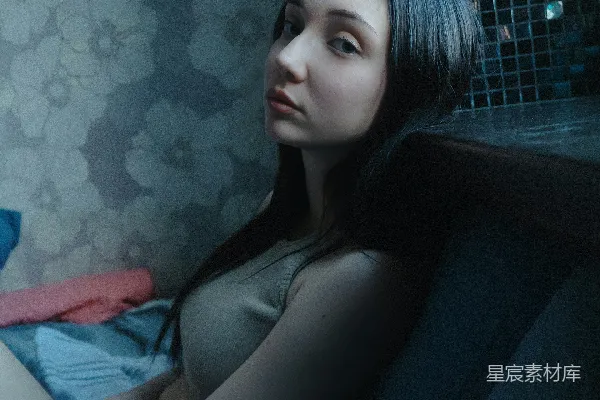 一个女人坐在沙发上，房间中。