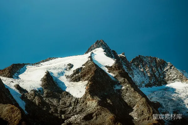 蓝天下覆白雪的山峦