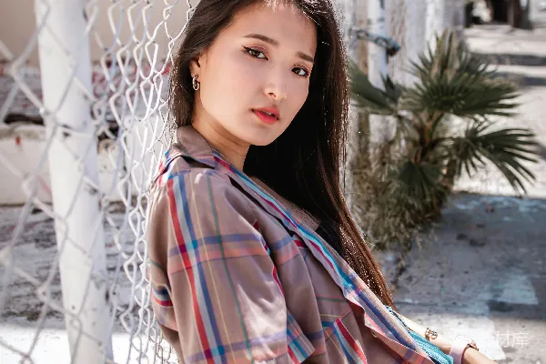 红色蓝色格子衬衫和蓝色牛仔裤的女人坐在混凝土地板上