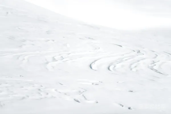 一个男人在覆盖着白雪的山坡上滑翔俯冲而下