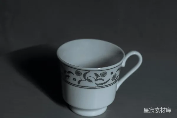 桌子上放着一个白色的杯子。