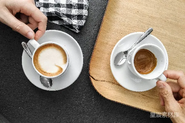 手持白色陶瓷杯的人手中握着一杯棕色液体