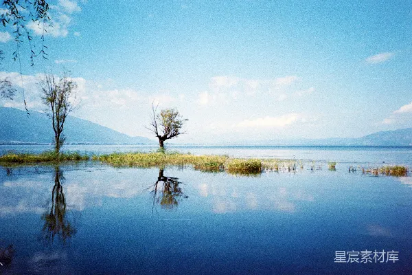 平静的湖水倒映着树木和山峦。