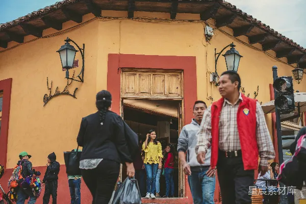 黑色夹克的男人站在一位戴白围巾和红色围巾的女人旁边。