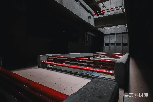 高清摄影 黑暗的混凝土建筑内部，红色护栏和多个楼层。