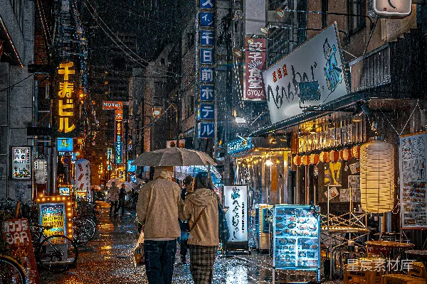 几个人走在街上拿着雨伞