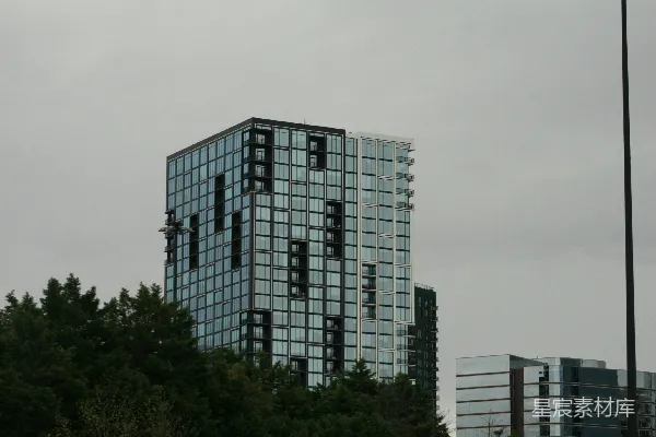 现代玻璃建筑矗立在阴云密布的天空下