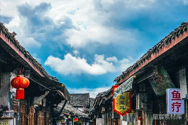 一条狭窄的街道两旁是木制建筑，在阴云密布的天空下。