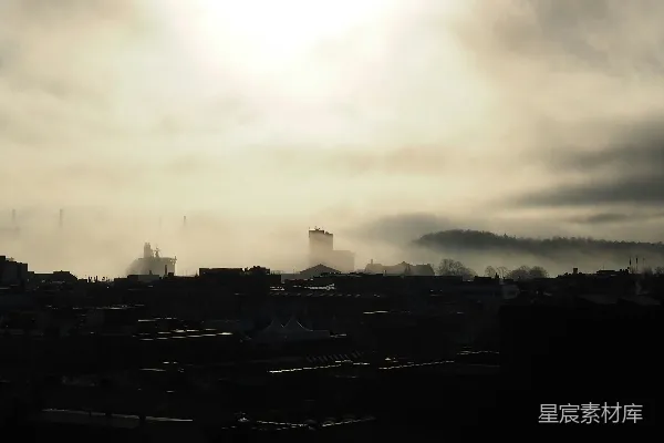 透过云层的阳光照耀在一座城市上