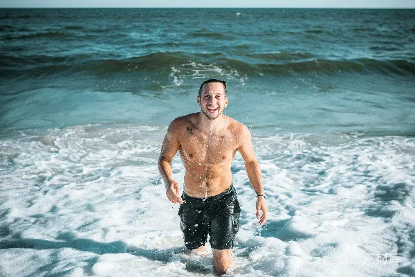 黑色短裤的男人站在海水中白天