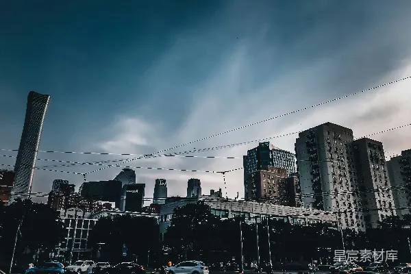 路面上的车辆靠近高-rise建筑物处的日间景象