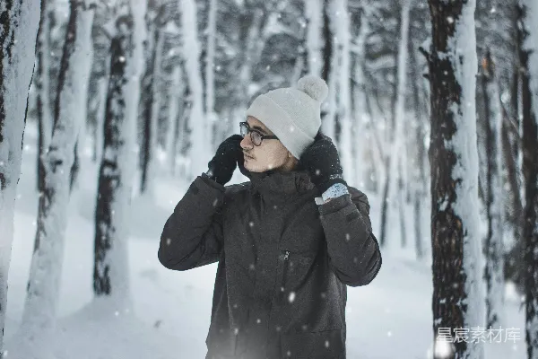 站在雪中的女子前面是树木
