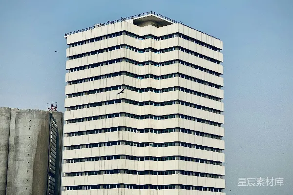现代白色办公楼矗立在晴朗的蓝天之下