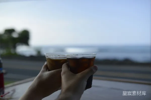 几个装有液体的玻璃杯放在海滩上
