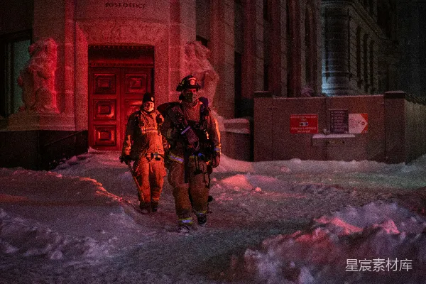 几个消防员走在覆盖着积雪的街道上