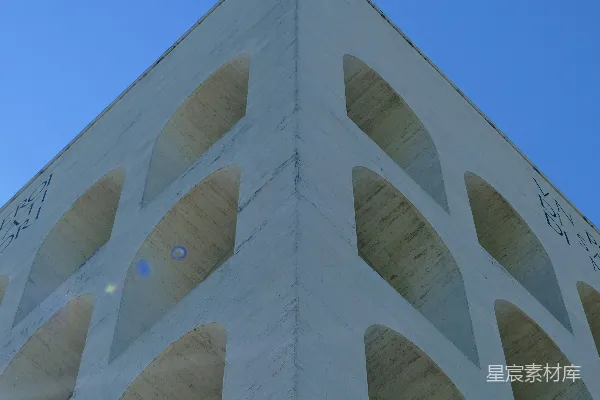 现代建筑 facade 上方有拱形窗户，背景是蔚蓝的天空。