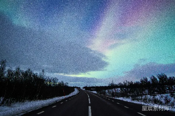 北欧光瀑在一片雪地和星空之下的公路旁。
