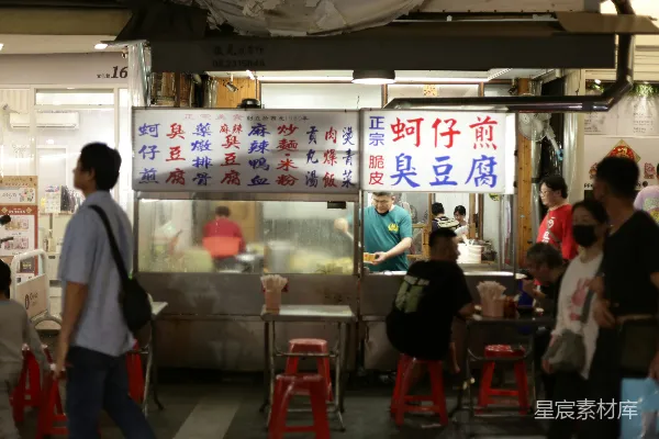 夜市摊位上人们在晚上点餐。