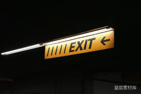 高清摄影 一盏黄色的出口指示灯挂在建筑物的侧面。
