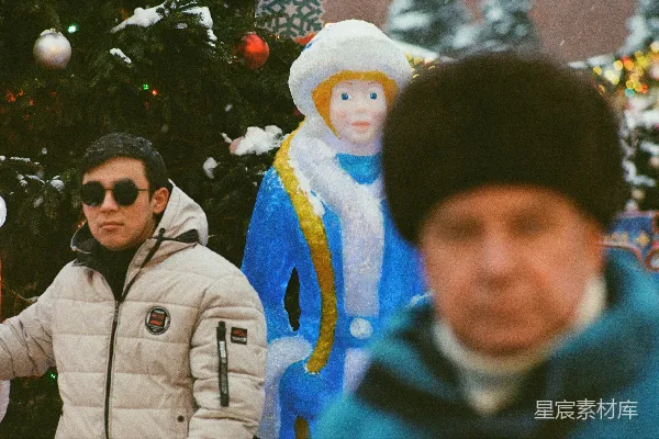 一个男人站在一棵圣诞树前