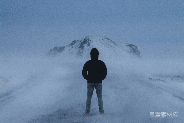 黑色夹克的人站在覆有积雪的地面上，在白天。