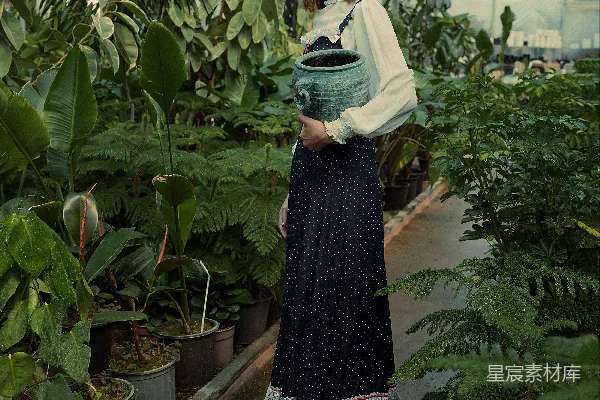 一个女人站在温室里戴着帽子