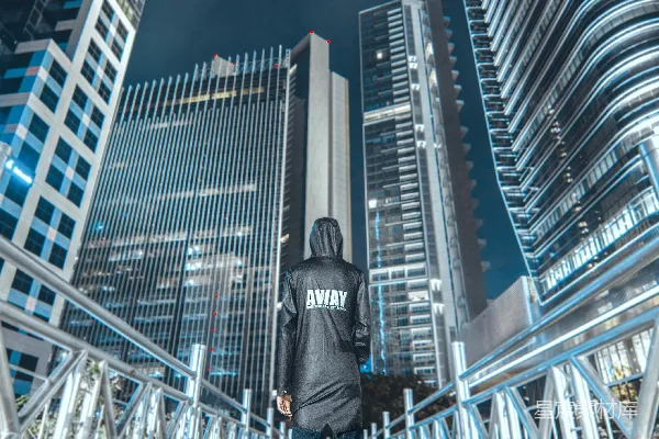穿着灰色夹克和黑色裤子的男人站在桥上