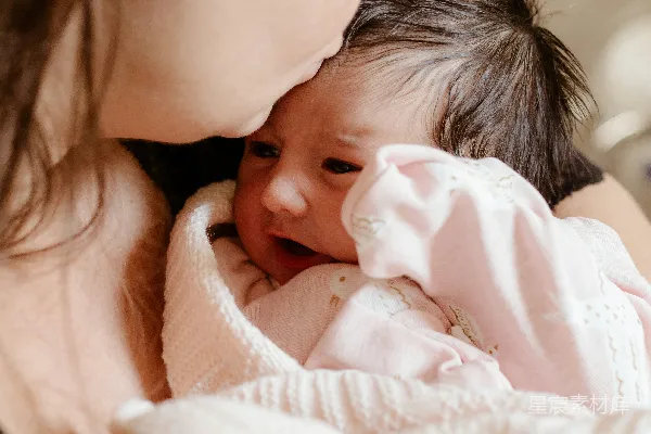 一个女人抱着一个裹着毯子的婴儿