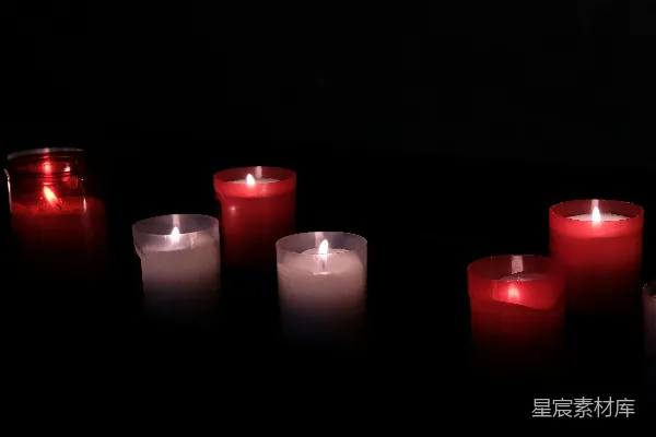 桌上摆放着一排点燃的蜡烛