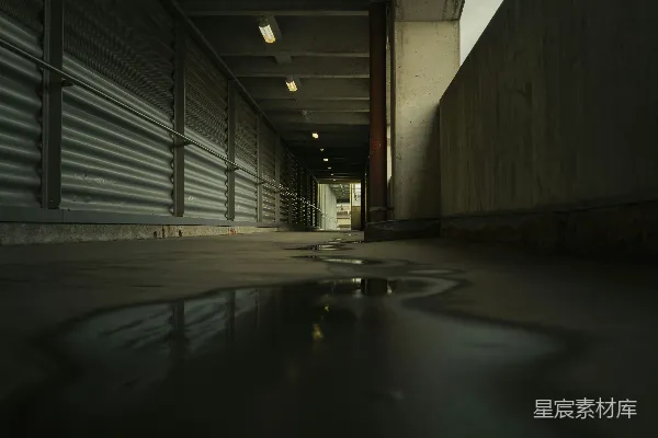 高清摄影 一个昏暗的走廊，地上有一滩水。