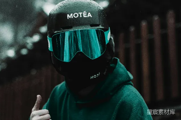 一个穿着绿色抓斗衫和护目镜的男人竖起大拇指