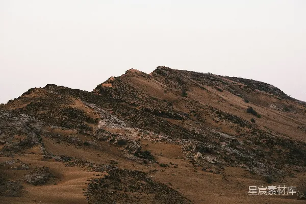 白天白天里棕色和白色的山峦在白色天空下